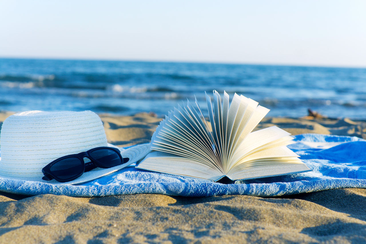 Straw hat ,sunglasses, book and seashell in the sand
** Note: Shallow depth of field